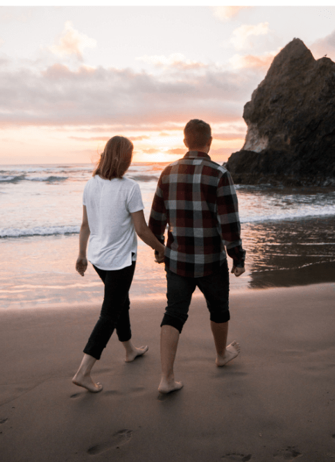 A couple taking a walk at the each showing the 7 qualities of a healthy relationship.