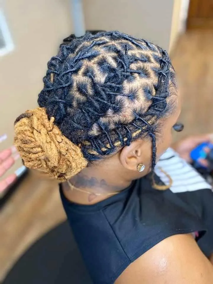 A corporate woman with medium-length dark locs styled into a sleek, polished low bun, ideal for boardroom meetings.