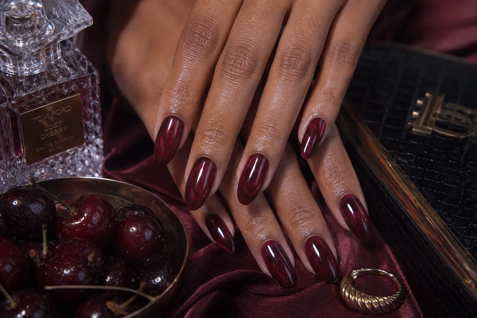 Long oval nails layered with translucent black cherry jelly polish