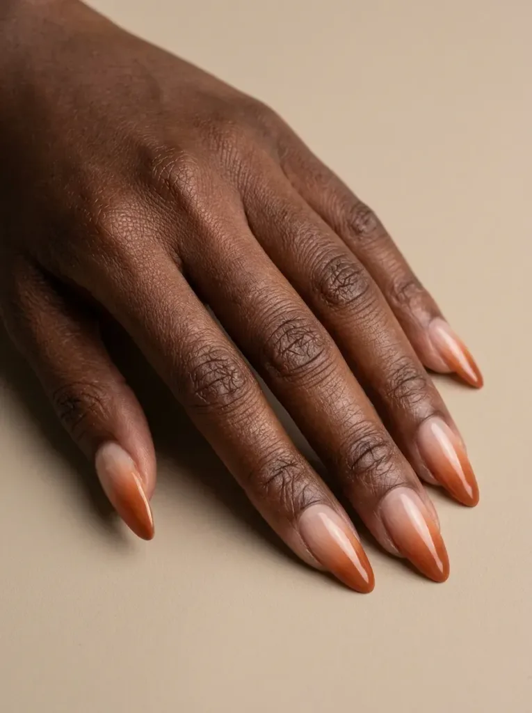Soft burnt orange French fade blending into sheer nude almond nails