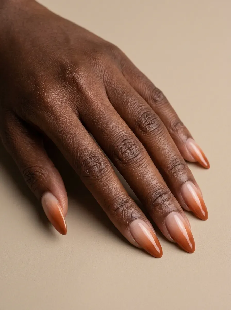 Soft burnt orange French fade blending into sheer nude almond nails