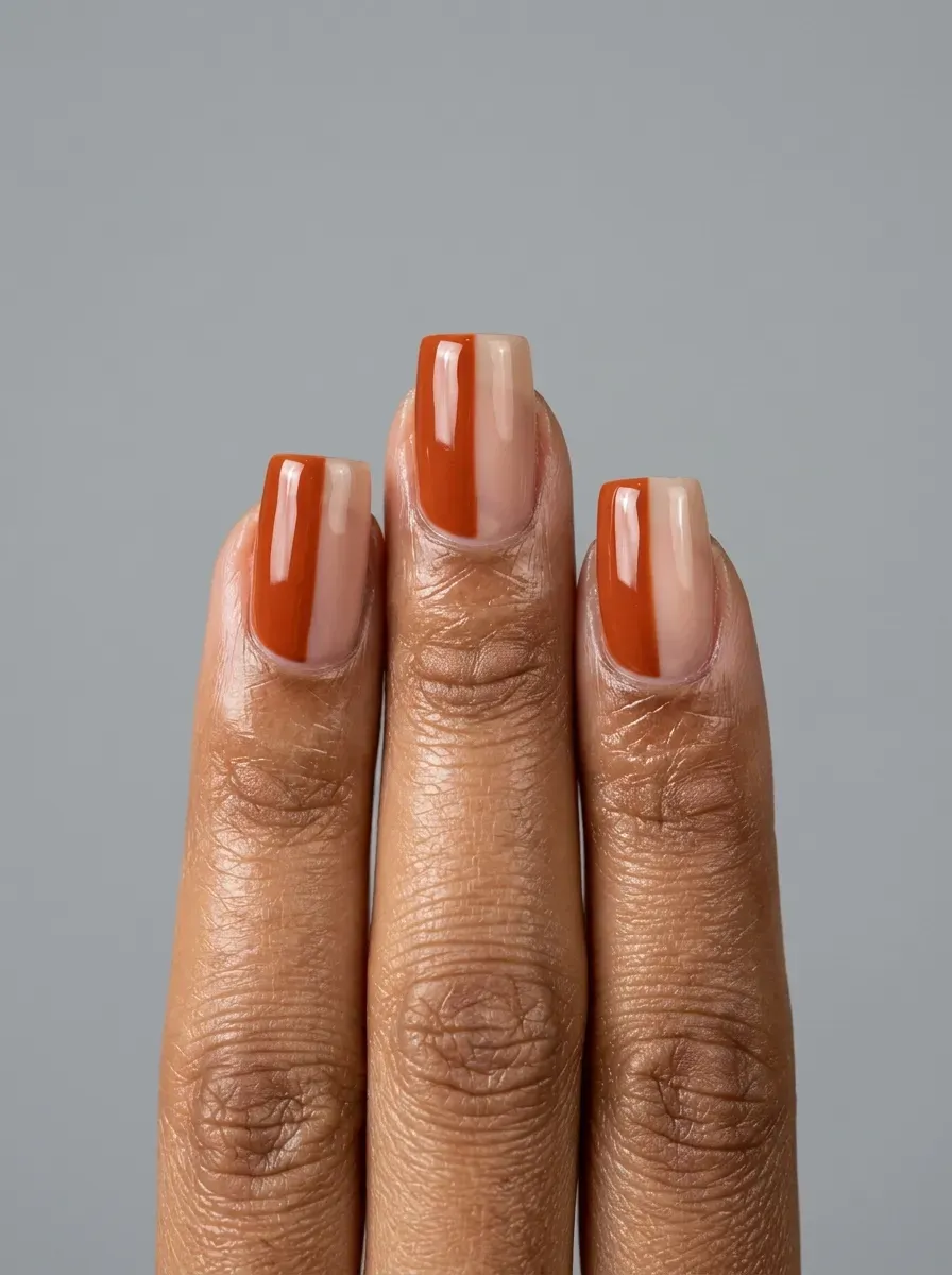 Burnt orange and sheer nude half-and-half manicure on medium square nails