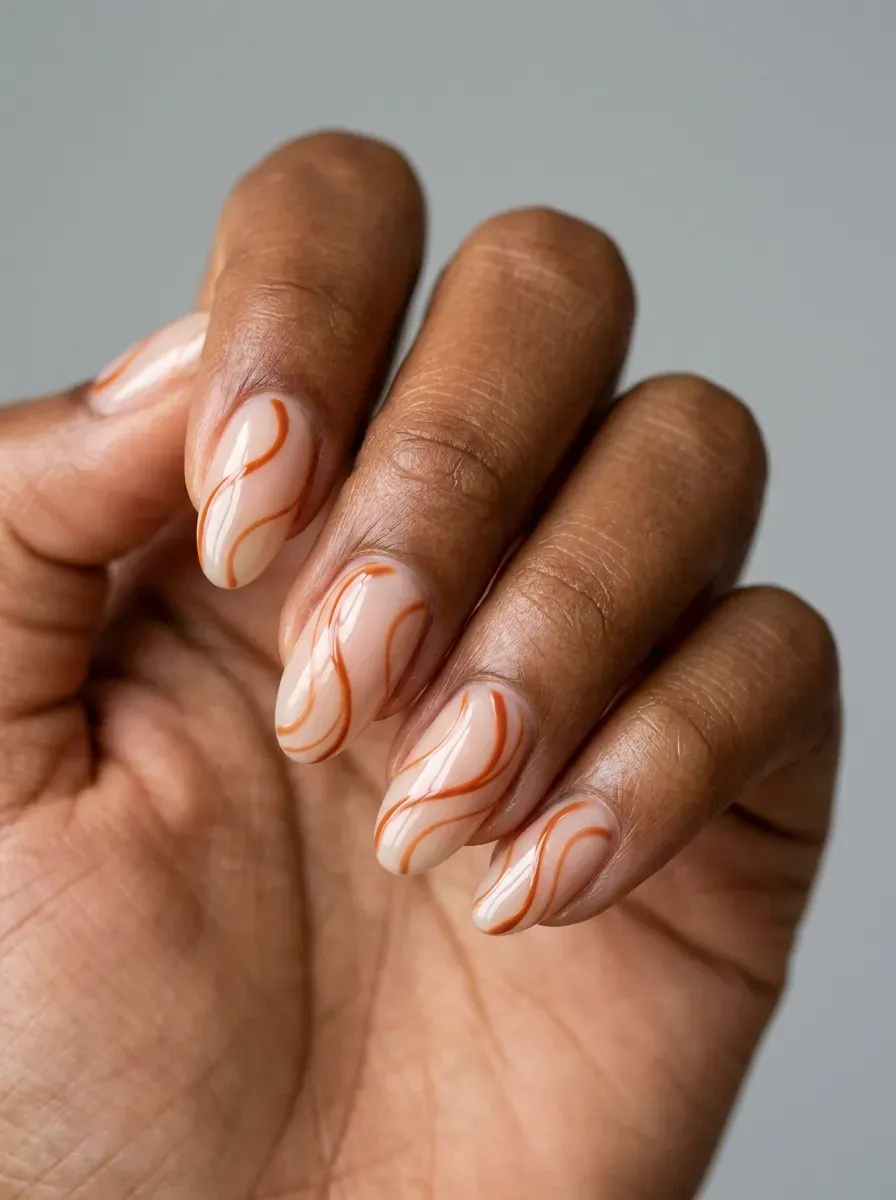 Sheer nude nails with flowing burnt orange swirl lines