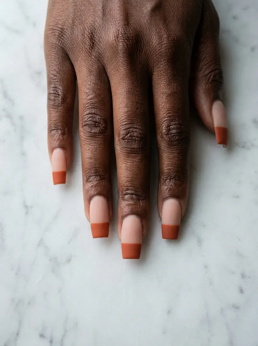 Coffin-shaped nails featuring a bold burnt orange French tip
