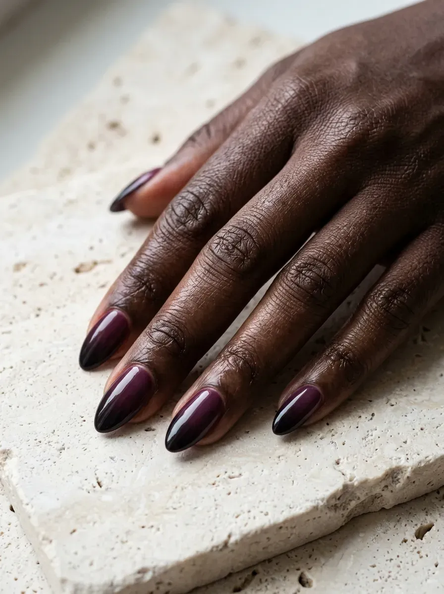Ombre nails blending deep plum into near-black at the tips