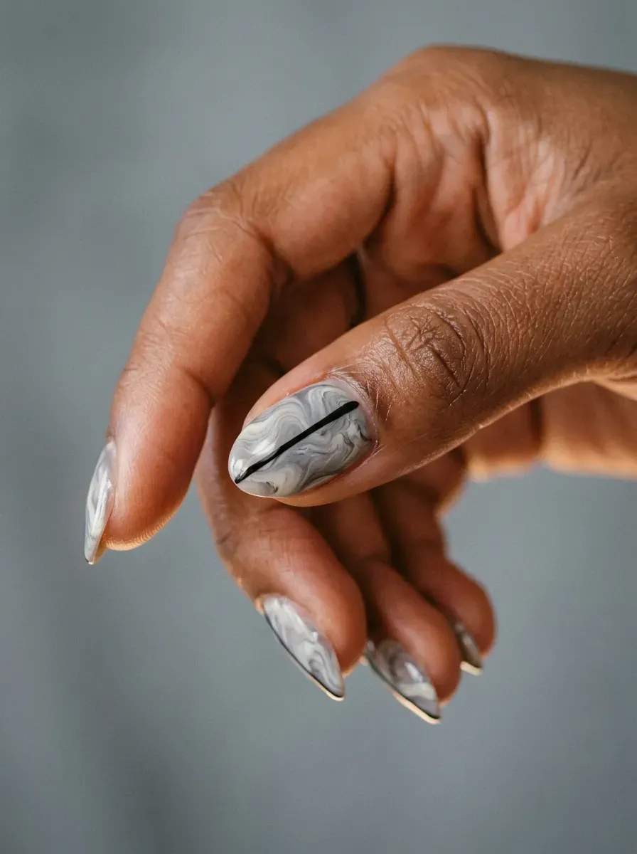 Soft gray and white marble swirl pattern on natural nails