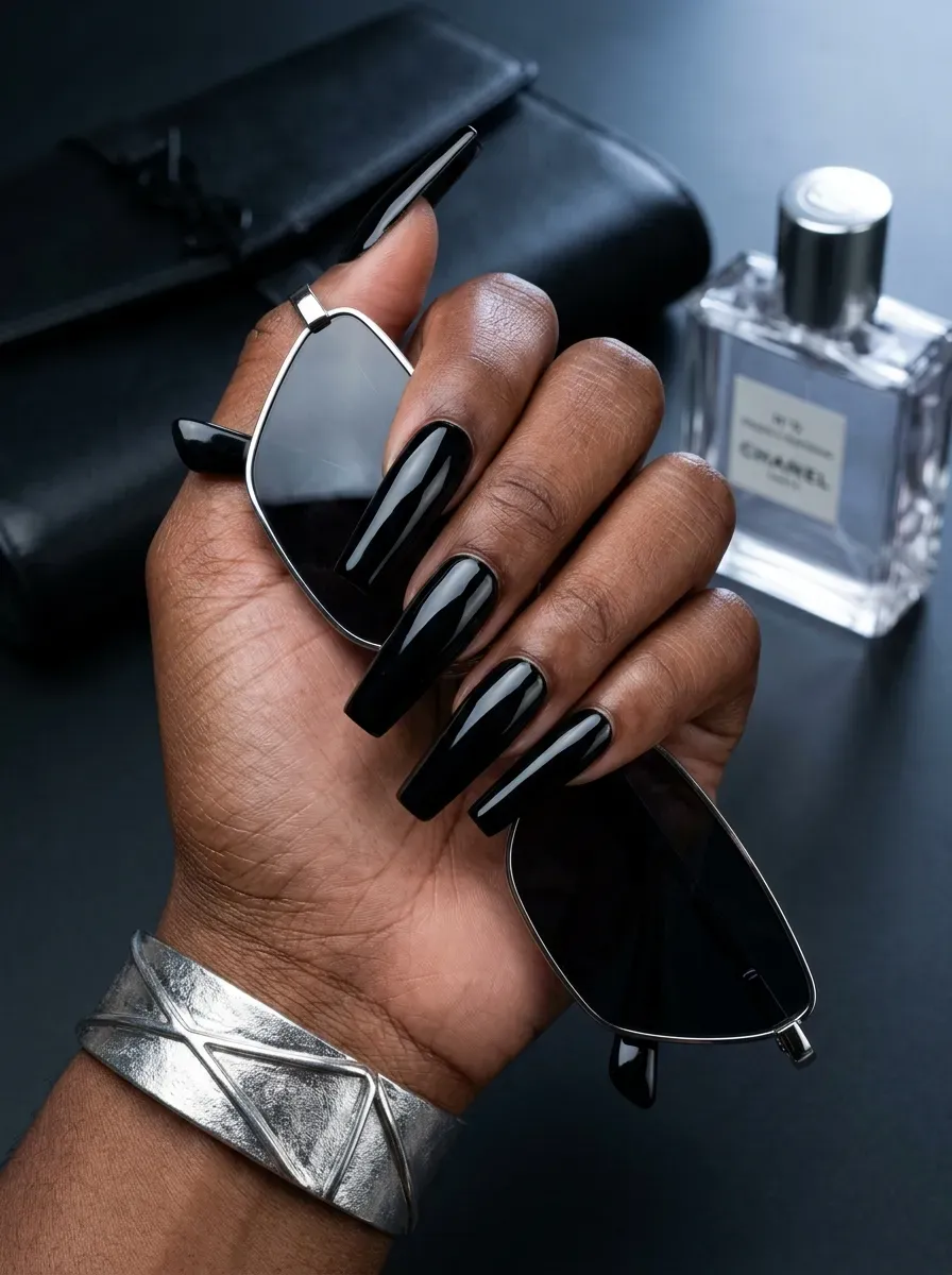 Long coffin nails painted glossy jet black on rich dark skin