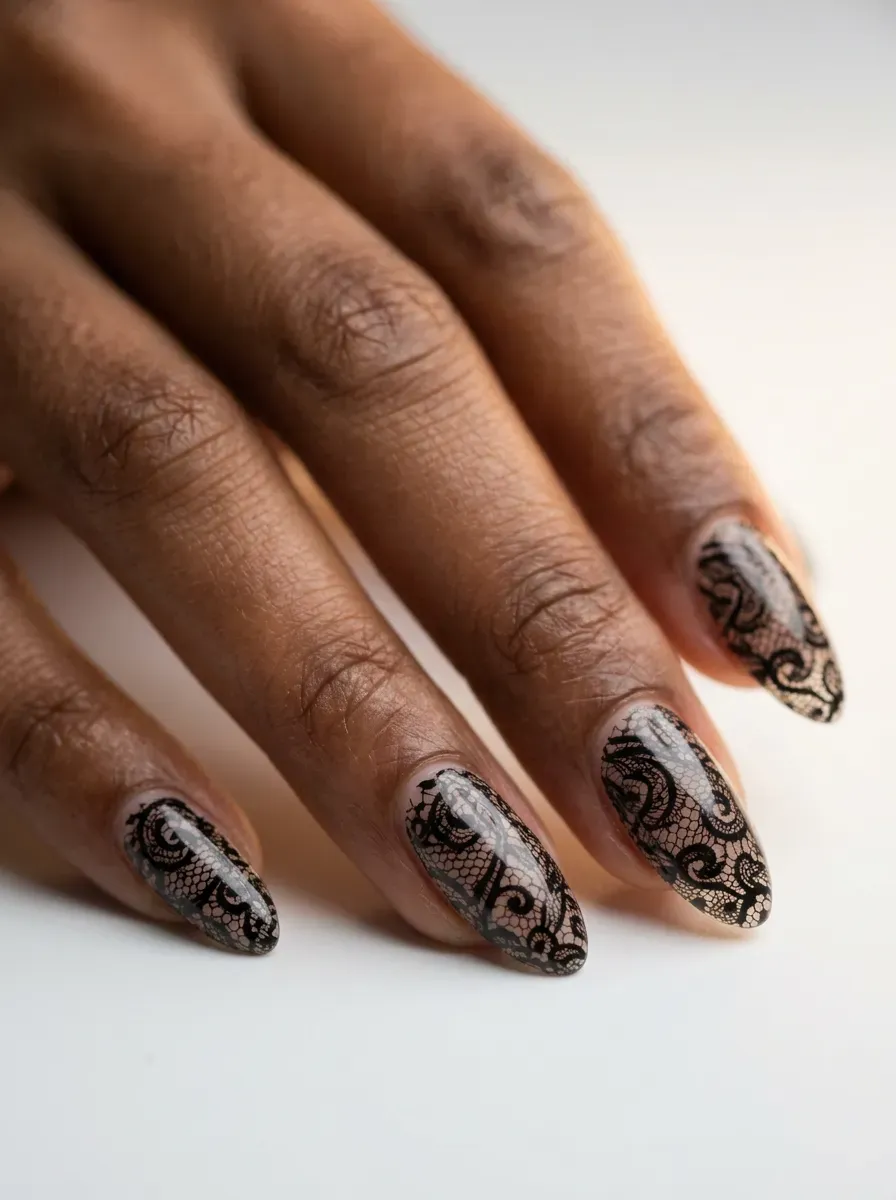 Delicate black lace pattern nail art over a pale base