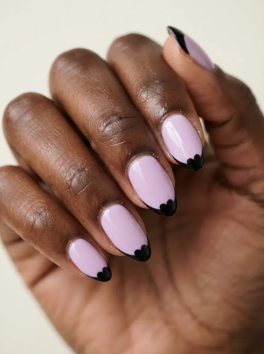 Lilac nails with black heart-shaped French tips on deep chestnut skin