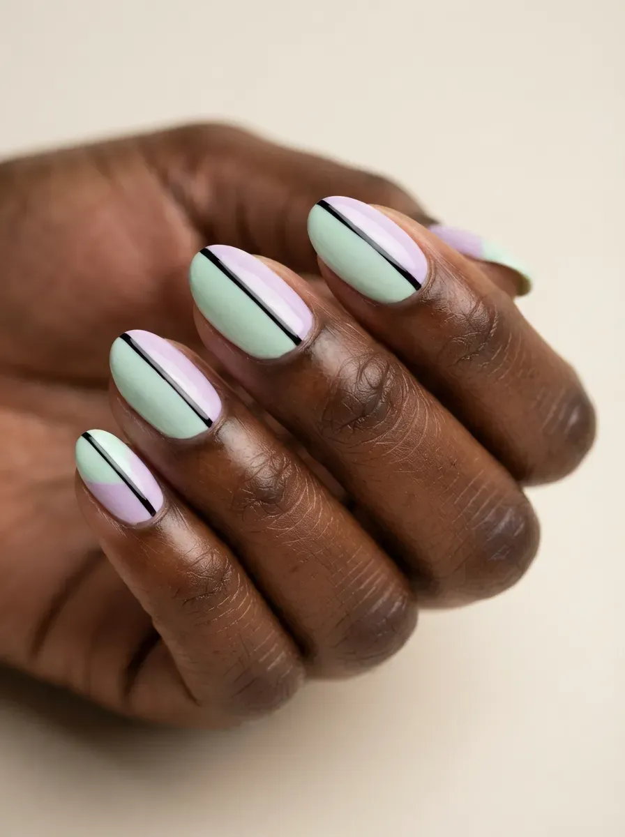 Mint and lilac split-color nails with thin black dividing lines on brown skin