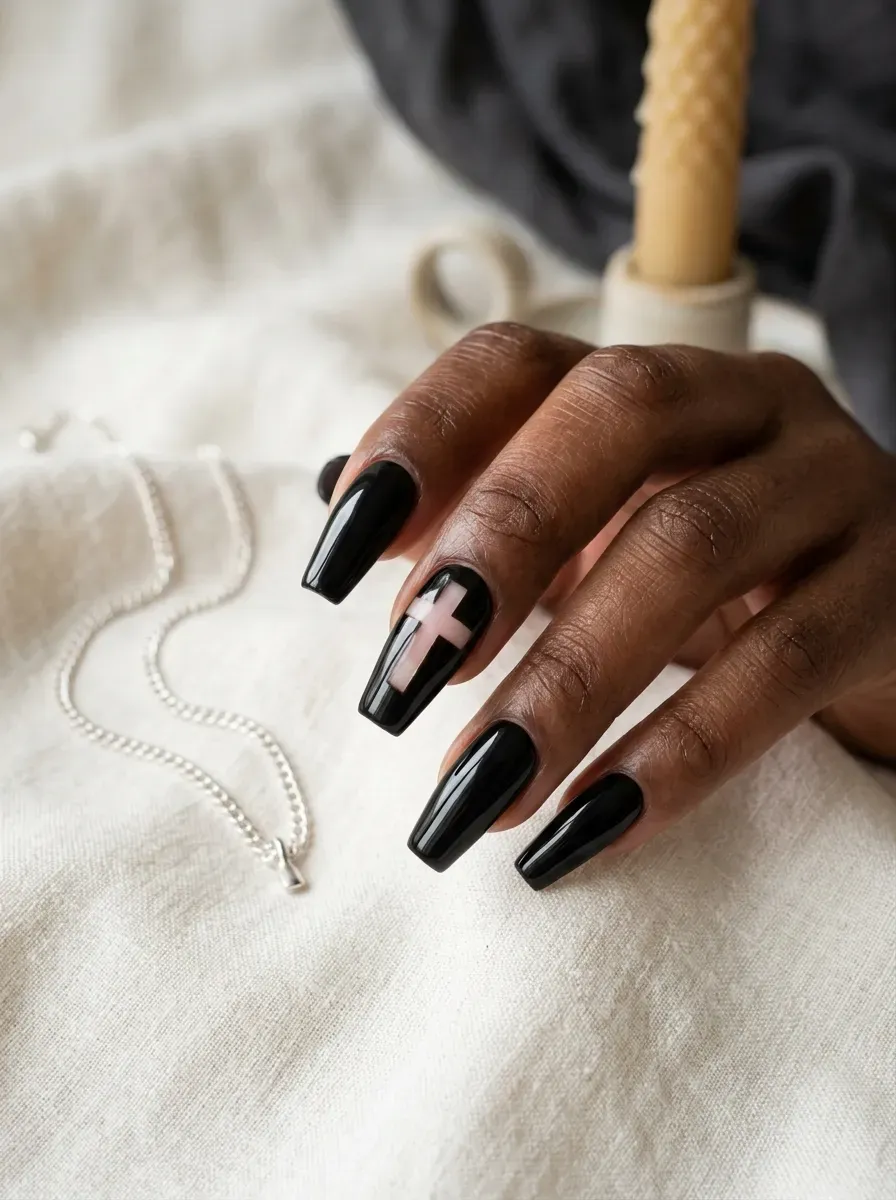 Long coffin nails with a black base and a bare cross shaped negative space cutout on deep chestnut skin