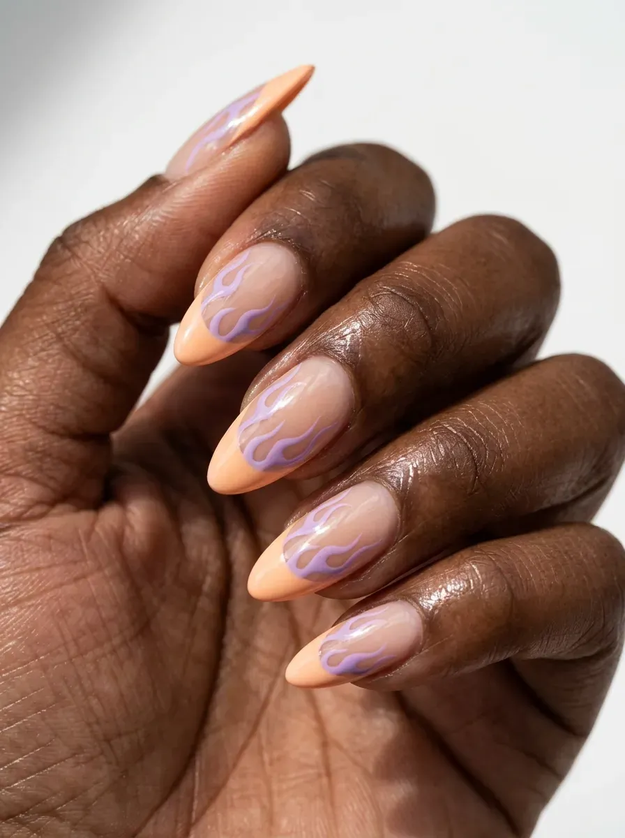 Long almond nails with pastel orange tips and purple flame accents