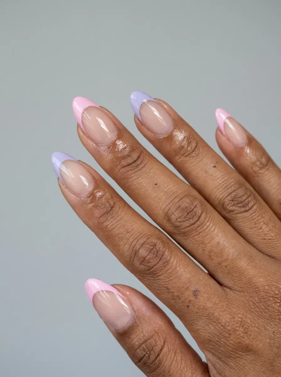 Medium almond nails with alternating pastel pink and purple French tips