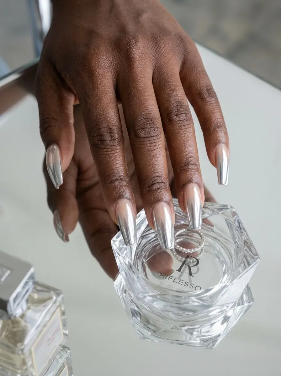 Silver chrome ombré French tips on coffin nails over dark skin