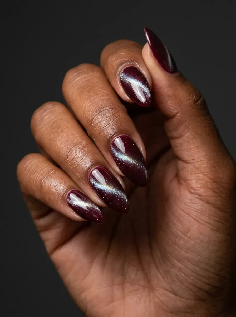 Burgundy cat-eye nails with magnetic shimmer on deep chestnut skin