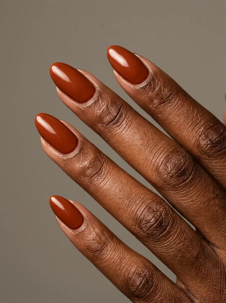 Burnt sienna gel nails with glossy finish on deep chestnut skin