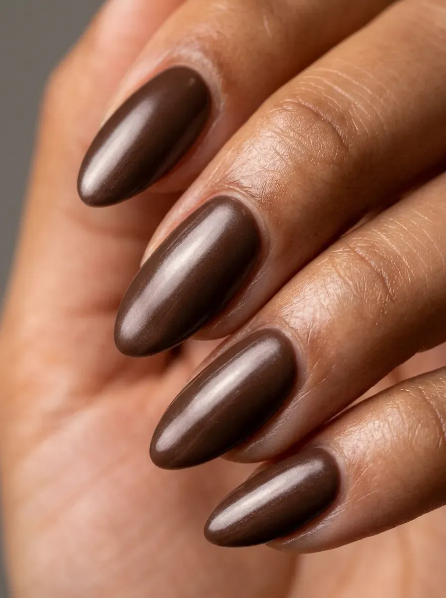 Chocolate brown glazed nails with reflective finish on warm brown skin