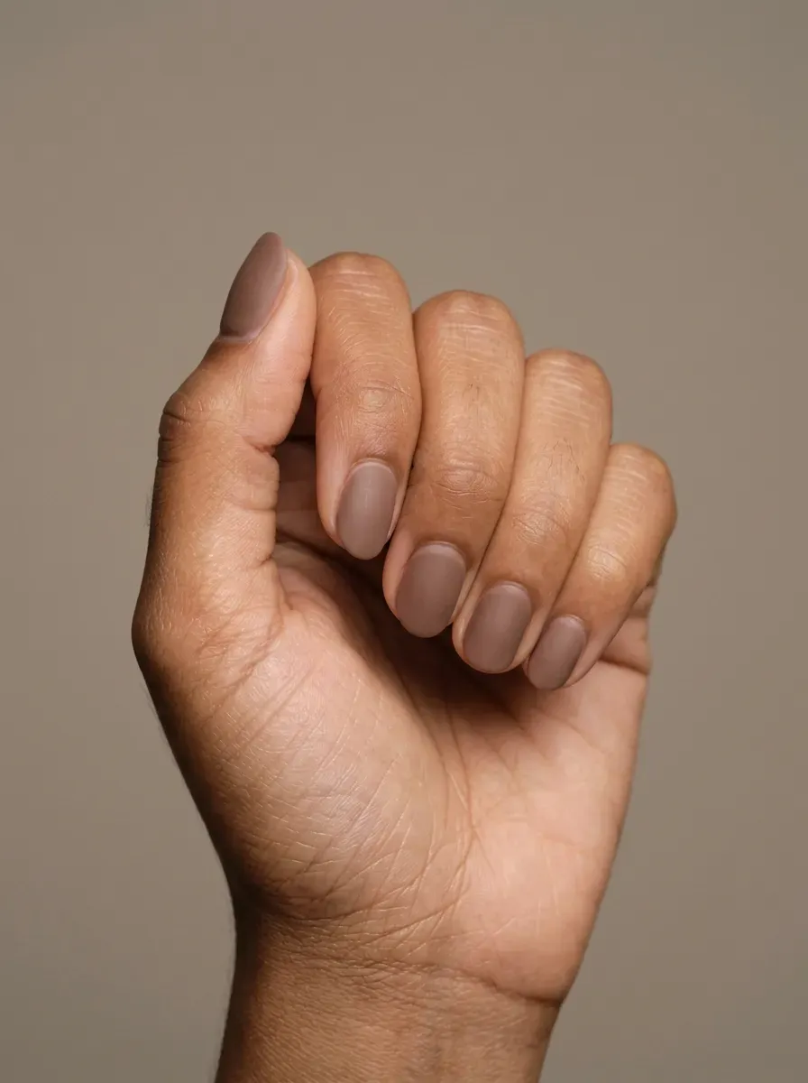 Cocoa beige matte nails with short rounded shape on brown skin