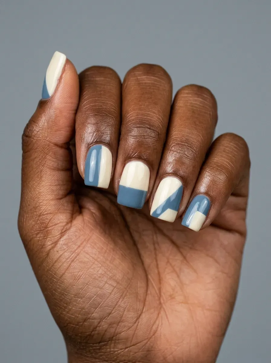 Short square gel nails with muted blue and cream geometric blocks
