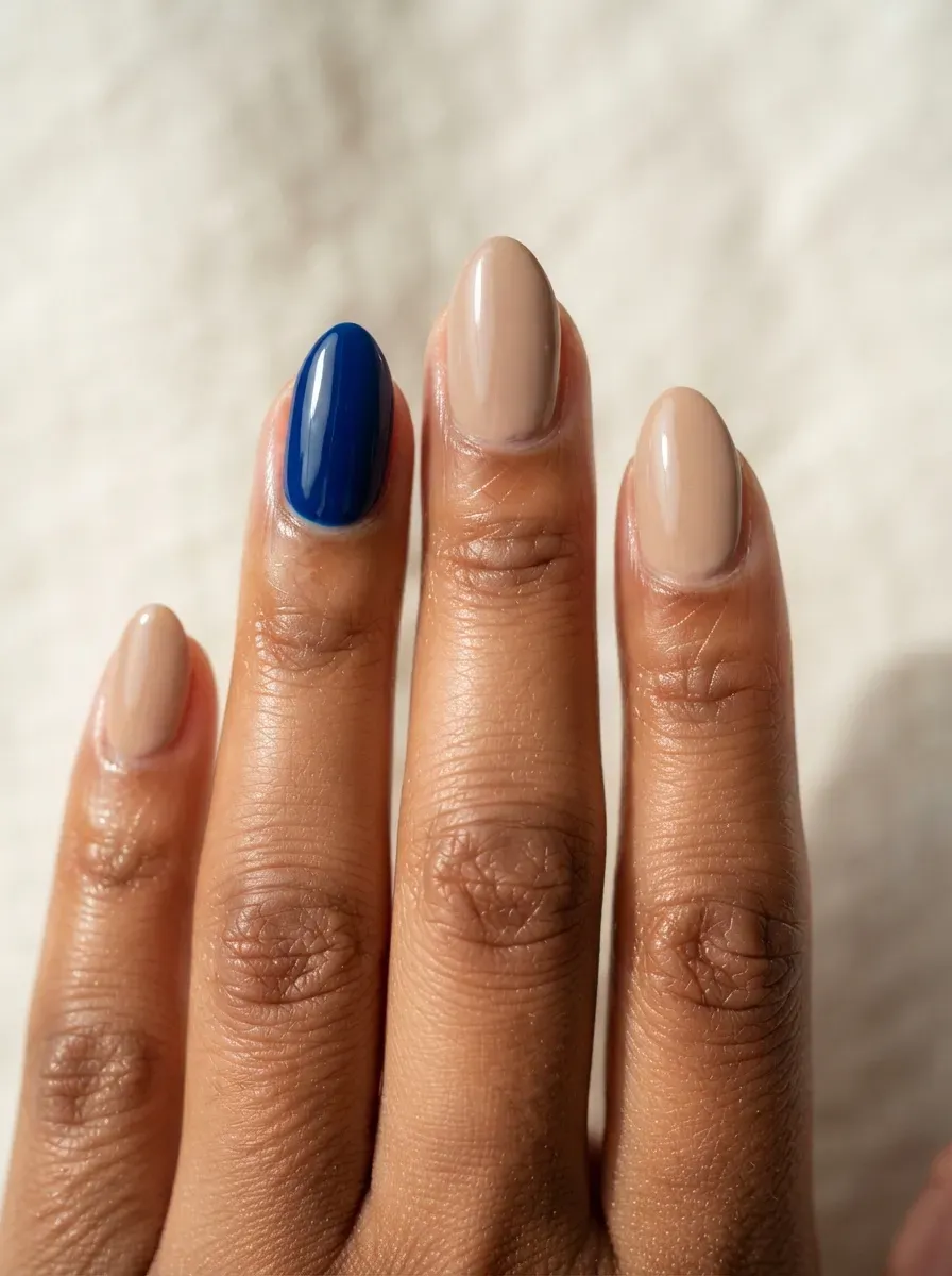 Deep sapphire blue accent nail paired with warm neutral nails