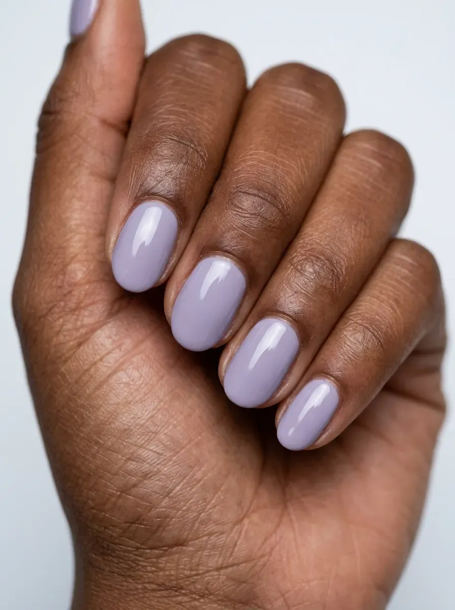 Short oval gel nails painted soft lavender with glossy finish
