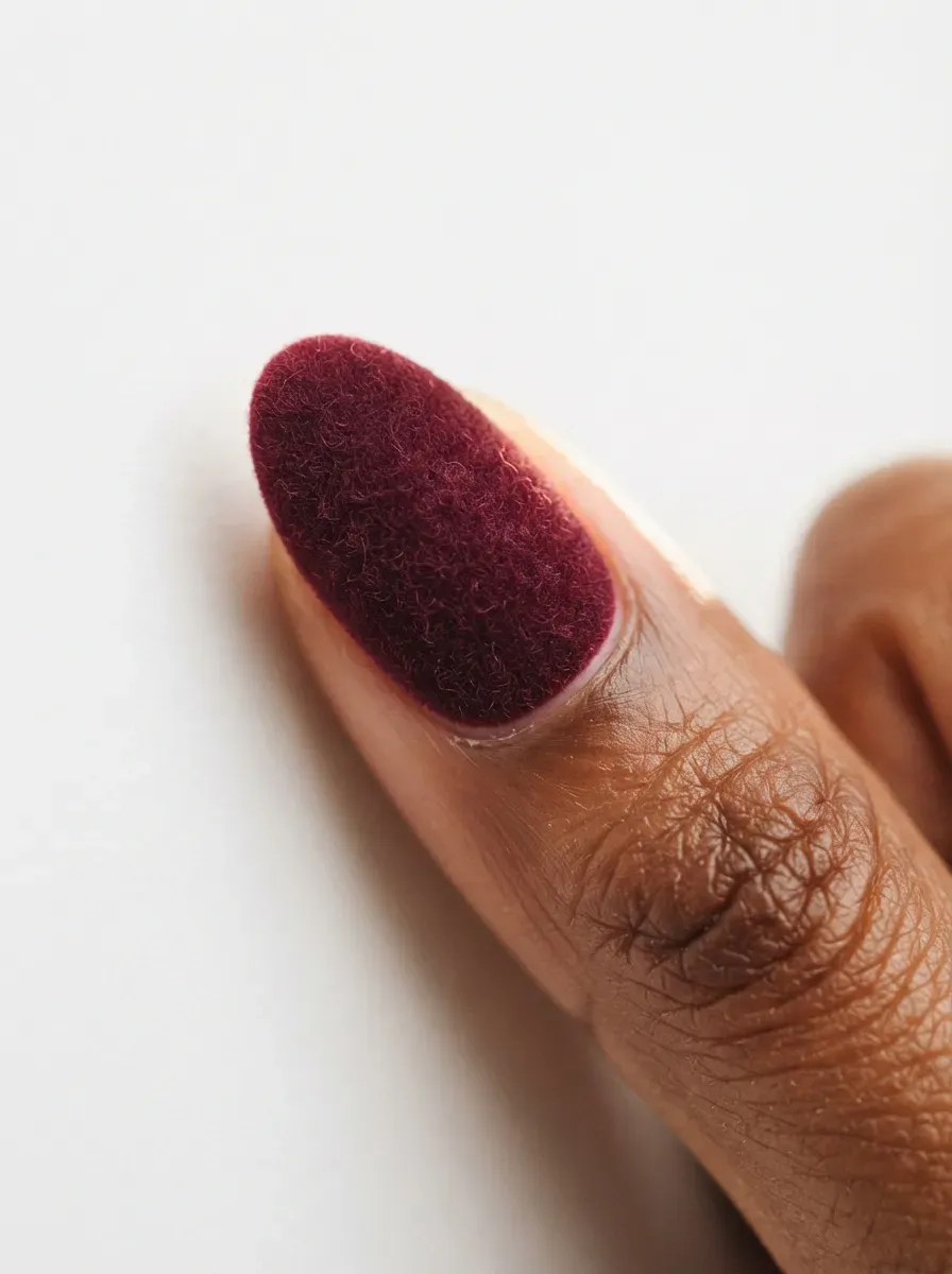 Deep wine red gel nails with a soft velvet-textured finish