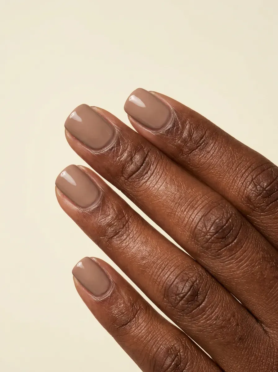 Warm taupe cream nails with smooth finish on deep chestnut skin