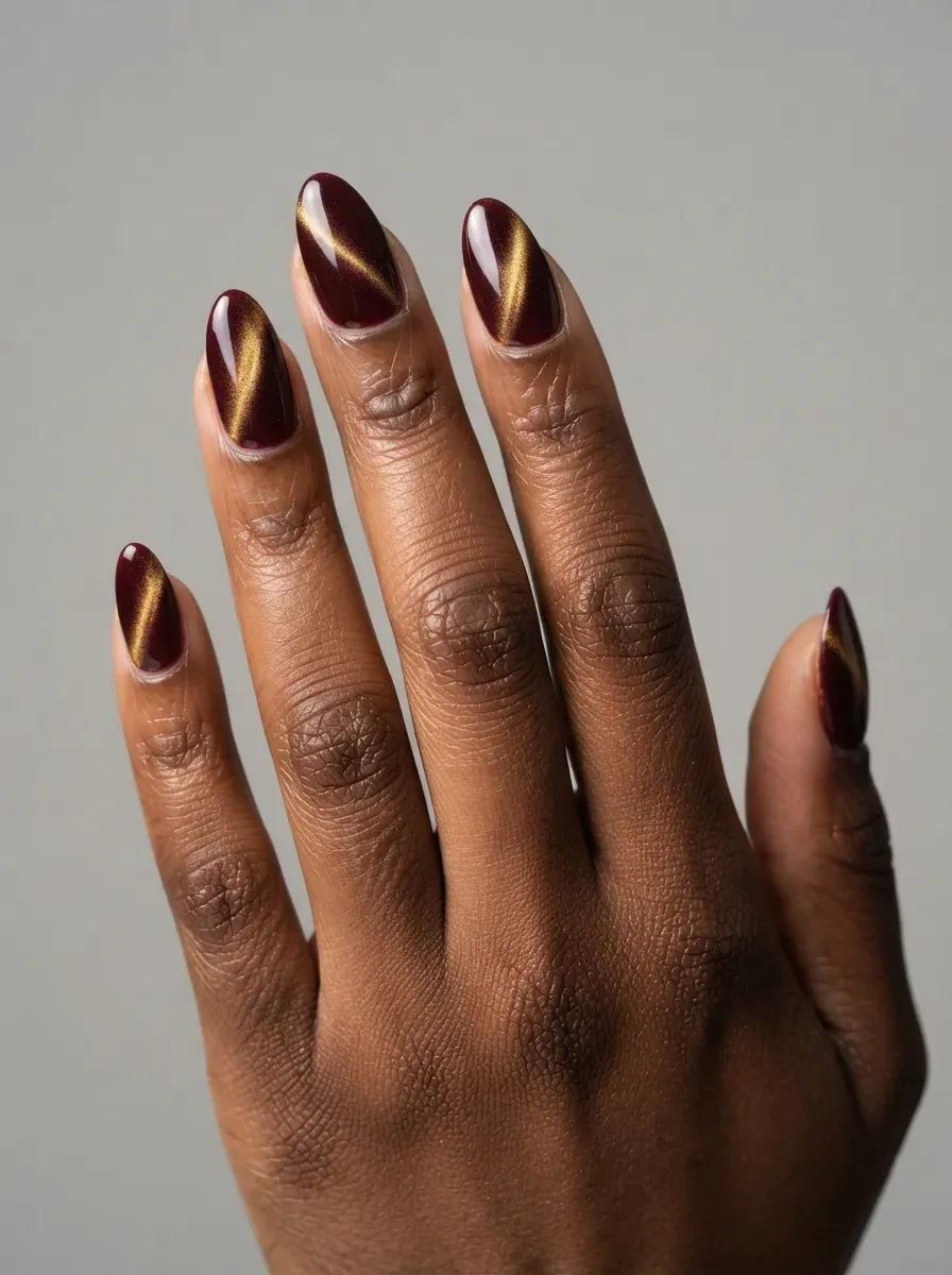 Burgundy nails with contrasting gold magnetic cat-eye reflections