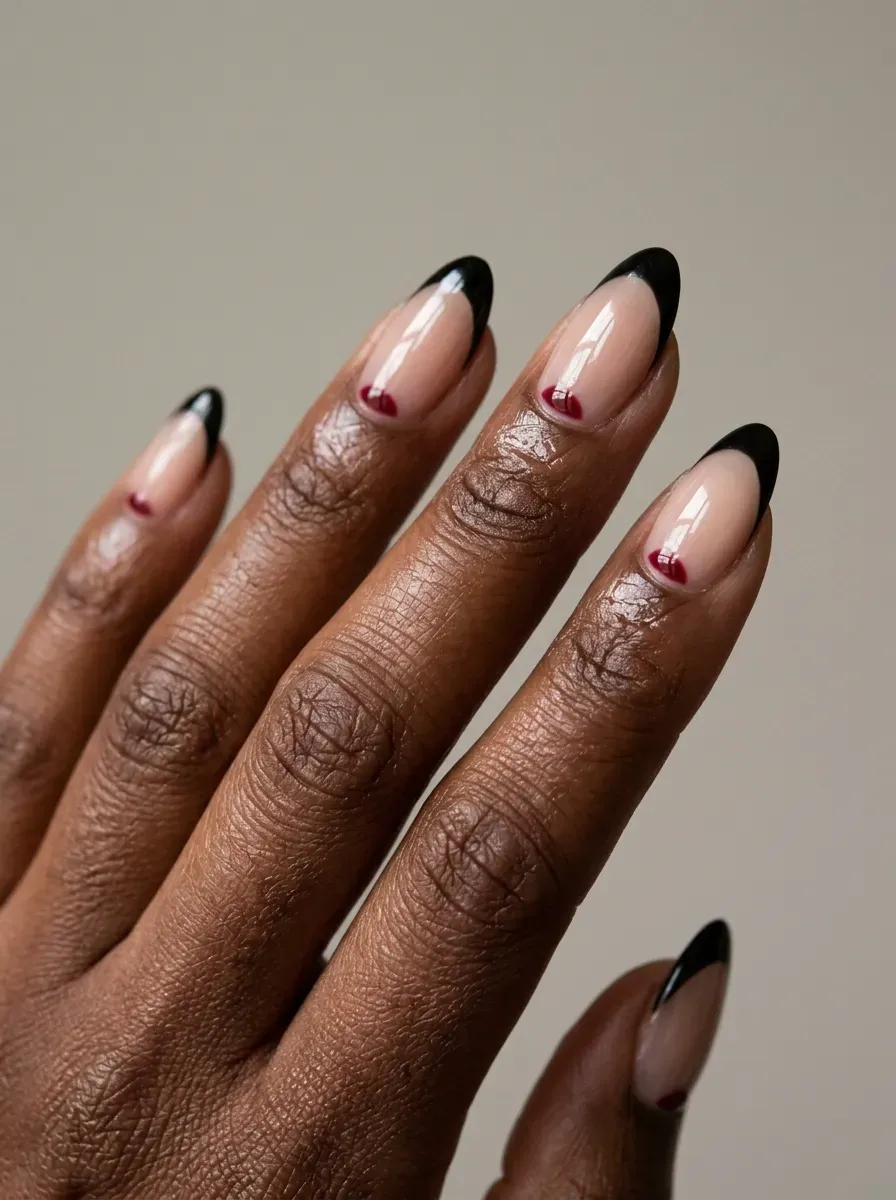 Black French tips with crimson crescent accents on sheer nude nails