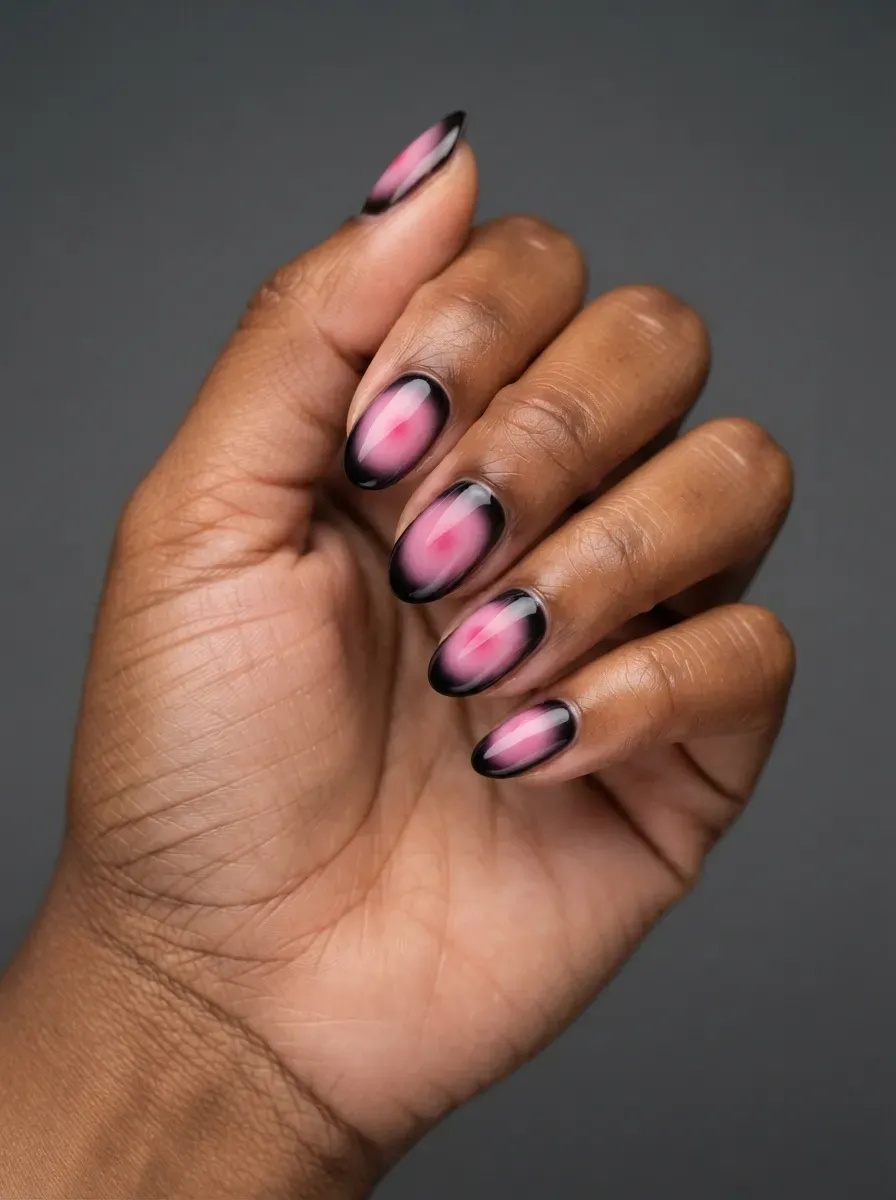 Close-up of nails with pink aura centers and black tips