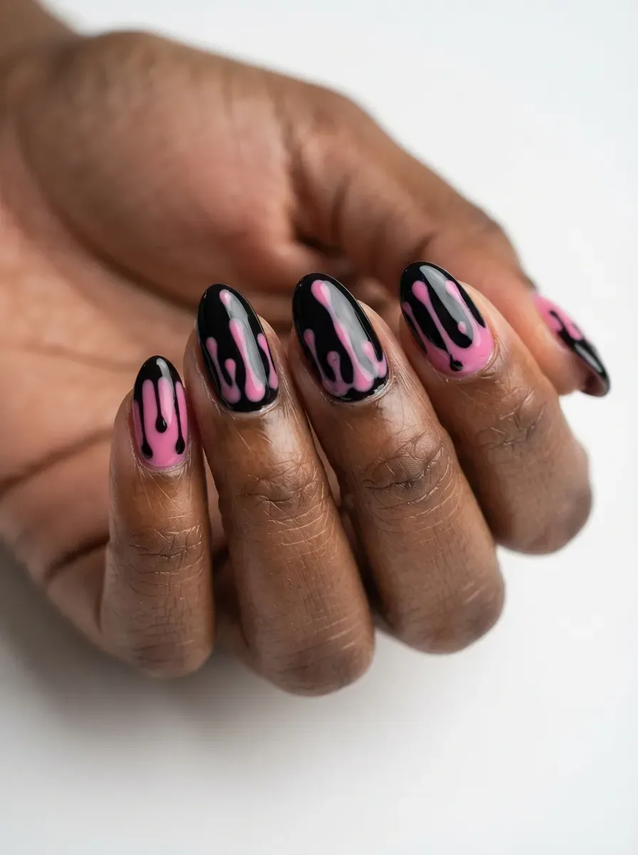 Close-up of glossy black nails with pink drip tips