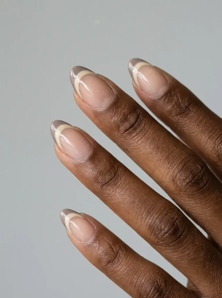 Medium almond nails with layered cream and taupe French tip bands