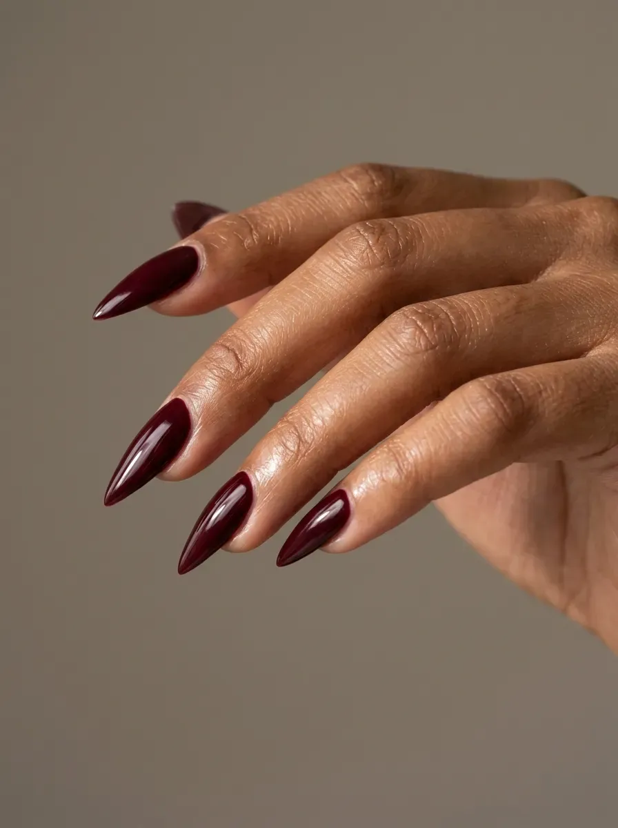 Long burgundy stiletto nails with glossy witchy Halloween-inspired finish